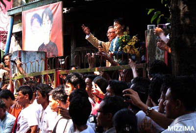 assk_picAung San Suu Kyi addresses thousands outside the National League for Democracy’s headquarters in Rangoon, on November 14, 2010. While extensive media presence captured the events of November 13 and 14, ensuing days have seen security tightened and those still lingering in the form of Suu Kyi paparazzi placed under increasing scrutiny. Photo: Mizzima.