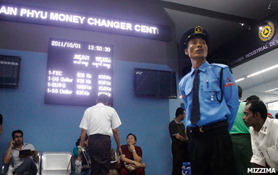 money-changer-centre-2s A security guard stands near a digital signboard displaying the currency exchange rates at Thain Phyu Money Changer Center in Rangoon in 2011. Photo: Mizzima money-changer-centre-2s A security guard stands near a digital signboard displaying the currency exchange rates at Thain Phyu Money Changer Center in Rangoon in 2011. Photo: Mizzima