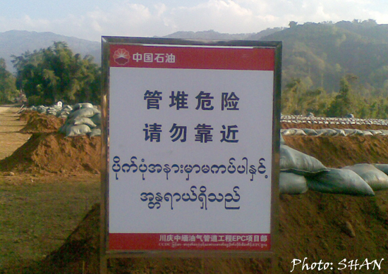 Notice in Chinese and Burmese warning people to keep away, at a football field in Namti tract, where pipes are being assembled (Photo: SHAN) Notice in Chinese and Burmese warning people to keep away, at a football field in Namti tract, where pipes are being assembled (Photo: SHAN)