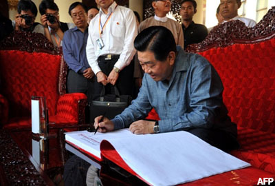 The chairman of the Chinese People's Political Consultative Conference Jia Qinglin signs the guest book at the Shwedagon Pagoda during his visit to Rangoon on April 4, 2011. Qinglin is on an official visit to Burma a few days after Myanmar's military made way for a nominally civilian government after almost half a century in power. AFP PHOTO/Soe Than Win Jia-Qinglin