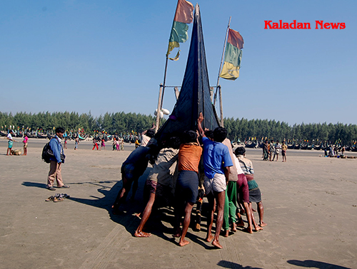 Fishermen pushing a fishing boat to the sea fishermen-01