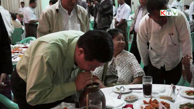 မြန်မာနိုင်ငံ ရထားပို့ဆောင်ရေးဝန်ကြီး ဦးအောင်မင်းမှ ကရင်နီတို့၏ ရိုးရာခေါင်ရည်ကို သောက်နေစဉ် (ဓါတ်ပုံ-ကေတီ)