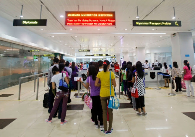 People line up as they wait in front of immigration inspection counters at Yangon International Airport