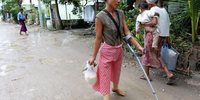Myanmar refugee Myat Win, 27, who lost both her legs after stepping on a landmine inside Myanmar, near the Thai border area, walks into the Mae Tao clinic grounds in the Thai - Myanmar border city of Mae Sot, Thailand. Photo: EPA