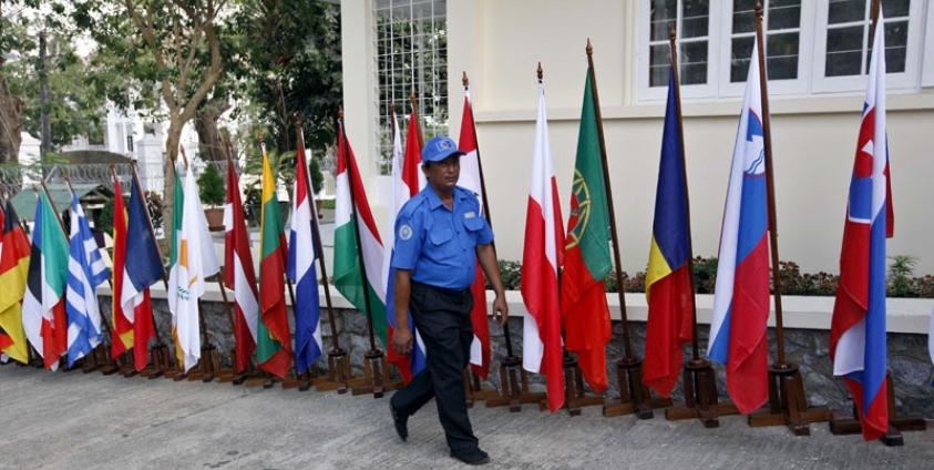 A security personnel walks past European countries flags during the opening ceremony of European Union office in Yangon, Myanmar, 28 April 2012. Photo: Nyein Chan Naing/EPA