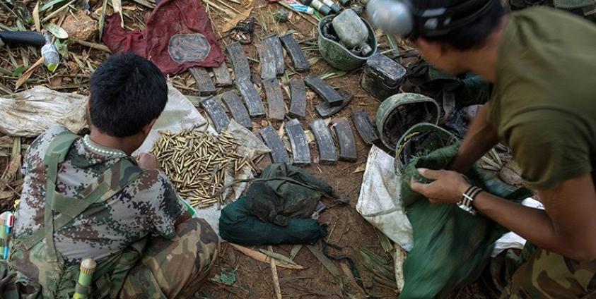 Rebels belonging to the Kachin Independence Army (KIA) ethnic group inspect government ammunitions and soldiers' helmets after two days of fighting with the Myanmar military near Laiza in Kachin State. Photo: AFP