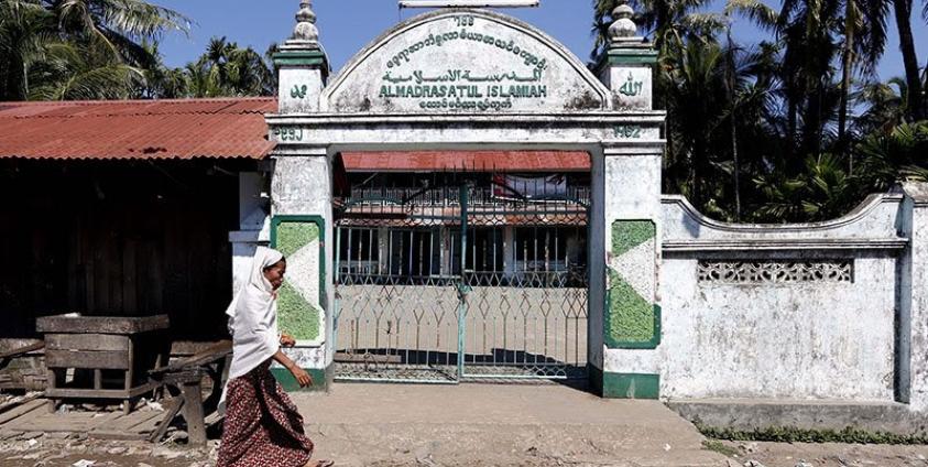 A Muslim woman walks by in front of the local mosque in the Aung Mingalar quarter in Sittwe, Myanmar. Photo: Nyein Chan Naing/EPA