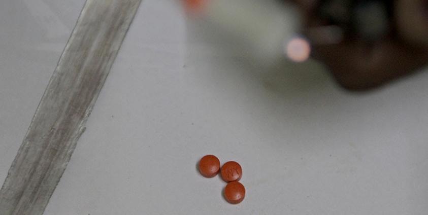 A man prepares methamphetamine pills before heating and inhaling them in a house on the outskirts of Yangon, Myanmar, 20 August 2014. Photo: Nyein Chan Naing/EPA