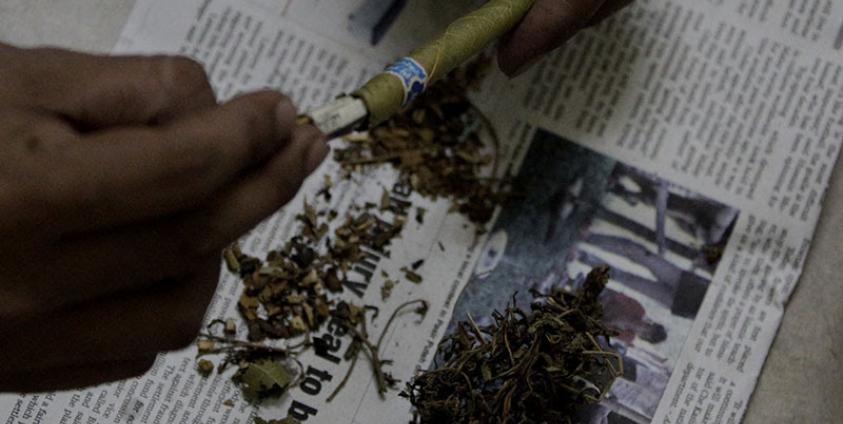 A man mixes marijuana and tobacco leaves from a typical Myanmar cheroot in a house on the outskirts of Yangon. Photo: Nyein Chan Naing/EPA