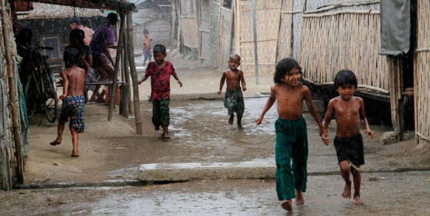 Rohingya children play during rain at an Internally Displaced Persons (IDPs) camp near Sittwe of Rakhine State, western Myanmar, 22 March 2016. Photo: Nyunt Win/EPA