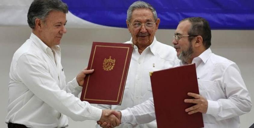 shake hands during a signing ceremony of a cease-fire and rebel disarmament deal, in Havana, Cuba. (AP Photo)