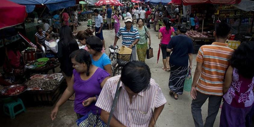 People walk through a street market in Yangon. Photo: AFP