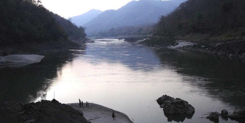 Plagued by war for decades - Here Karen villagers (small figures in foreground) arrive at safety along the Salween River after fleeing their homes in April 2006. Photo: Free Burma Rangers/EPA