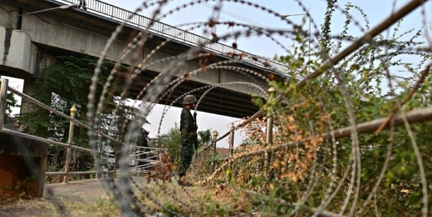 Thai military personnel stands guard overlooking the Moei river on the Thai side, near the Tak border checkpoint with Myanmar, in Thailand’s Mae Sot district on April 11, 2024. Myanmar junta troops have withdrawn from a major trade hub near the Thai border following days of clashes, an ethnic armed group told AFP on April 11, 2024, dealing a further blow to the embattled military. (Photo by MANAN VATSYAYANA / AFP)