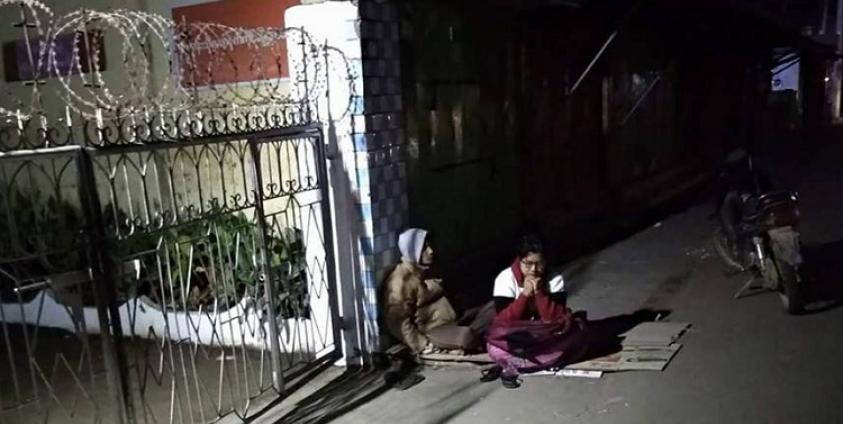 ကိုနိုင်စိုး ဖမ်းဆီးခံရသဖြင့် စိုးရိမ်နေကြသည့် မိသားစုဝင်များက အမှတ်(၁) ရဲစခန်းရှေ့တွင် တစ်ညလုံး ဤသို့ ငုတ်တုတ်ထိုင်၍ စောင့်နေခဲ့ကြသည်/ ဓာတ်ပုံ- မြတ်သူထွန်း