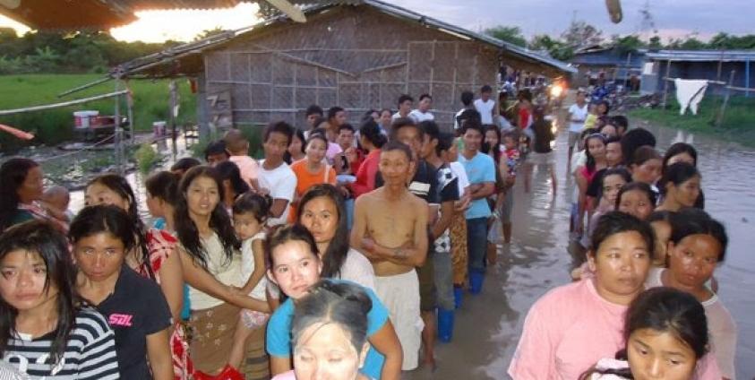 The migrant workers line up outside of a flooded camp in Chiang Mai