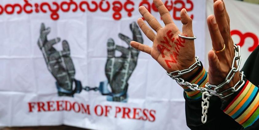 A reporter raises his hands while wearing chains during a demonstration held to demand the Myanmar government and Myanmar military release detained journalists, in front of Yangon City Hall, Yangon, Myanmar, 30 June 2017. Photo: Lynn Bo Bo/EPA