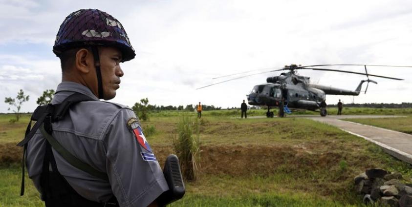 Police stands guard near the military transport helicopter at Maungdaw township in Rakhine State, western Myanmar, 27 September 2017. Photo: Nyein Chan Naing/EPA