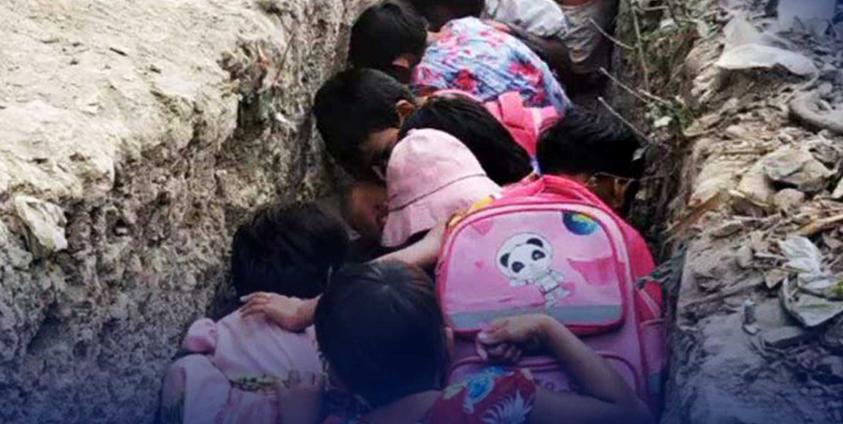 လေကြောင်းအန္တရာယ်ကြောင့် ဗုံးခိုကျင်းတစ်ခုတွင် ဝပ်နေကြရသည့် ရခိုင်က ကလေးငယ်များကို တွေ့ရစဉ်။ ဓာတ်ပုံ - လင်းရောင်ခြည်ဖောင်ဒေးရှင်း