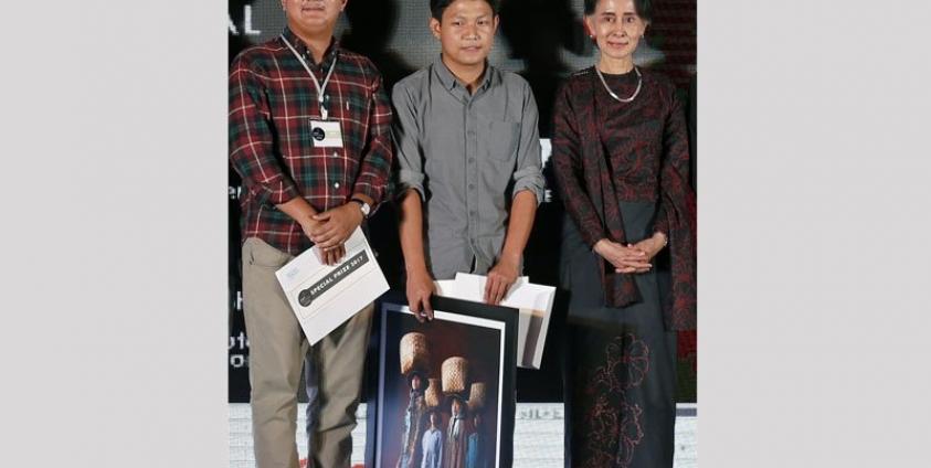 Photojournalists Min Zayar Oo (L) and Hkun Lat (C) pose for a photograph next to Myanmar's State Counselor Aung San Suu Kyi during the ninth Yangon Photo Festival at the Institut Francais de Birmanie School in Yangon, Myanmar, 11 March 2017. Photo: Nyein Chan Naing/EPA