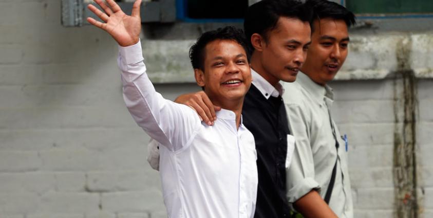 Weekly Eleven ဂျာနယ်ပါ ဆောင်းပါးရေးသားခဲ့သူ ဖြိုးဝေ (လက်ပြနေသူ) အား တာမွေရဲစခန်းသို့ လာရောက်အဖမ်းခံရာတွင် တွေ့မြင်ရစဉ်။ဓာတ်ပုံ - EPA-EFE/LYNN BO BO