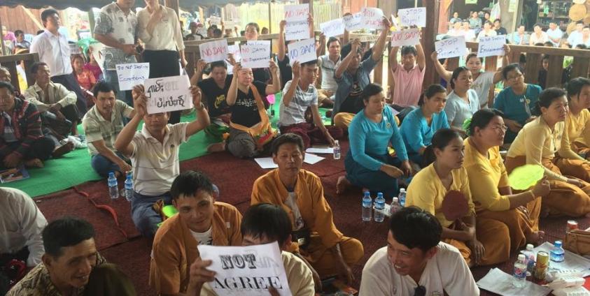 People Hold Signs Opposing the Dam Project