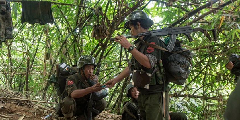In this photograph taken October 14, 2016, armed rebels belonging to KIA ethnic group take a cigarette break as they move towards the frontline near Laiza in Kachin state. Photo: Hkun Lat/AFP