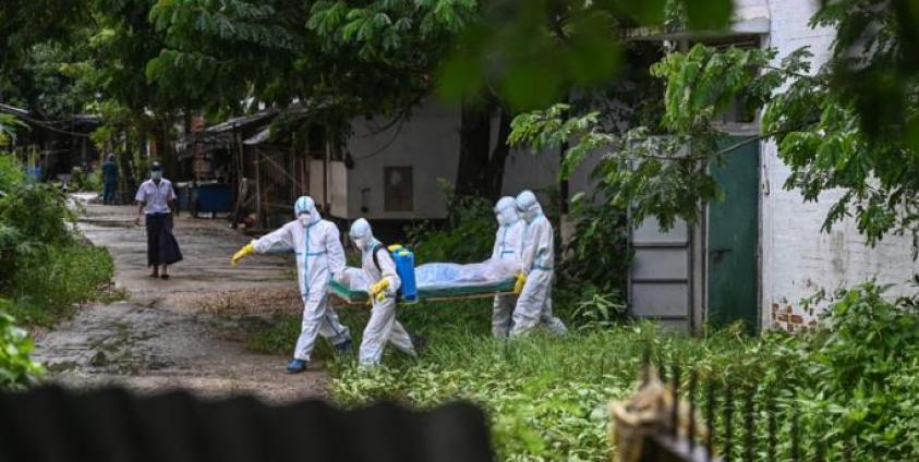 Volunteers wearing personal protective equipment (PPE) carry the body of a victim of the Covid-19 coronavirus to a cemetery in Hlegu Township in Yangon on July 10, 2021. Photo: AFP