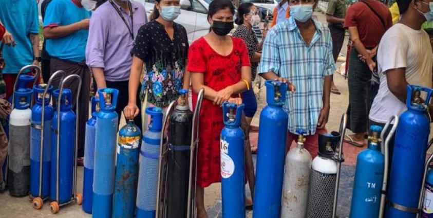 This picture taken on July 14, 2021 shows people waiting to fill empty oxygen canisters at a location donating oxygen at no cost in Yangon, amid a surge in the number of Covid-19 coronavirus cases. Photo: AFP