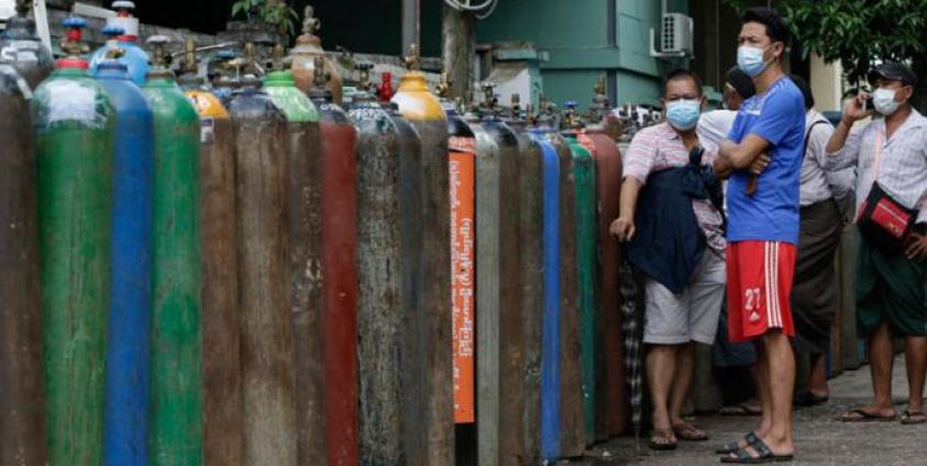 Myanmar people wait near oxygen tanks lined up to refill outside an oxygen factory in Yangon, Myanmar, 11 July 2021. Photo: EPA