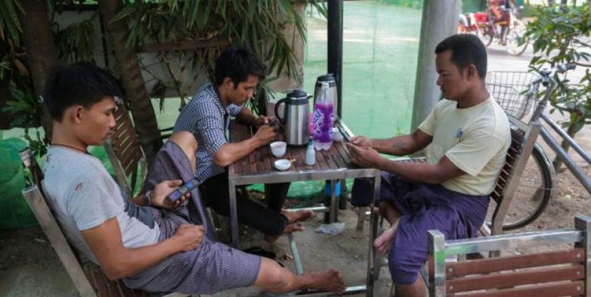 Myanmar men using their mobile phones at a teashop in Yangon. Photo: Sai Aung Main/AFP