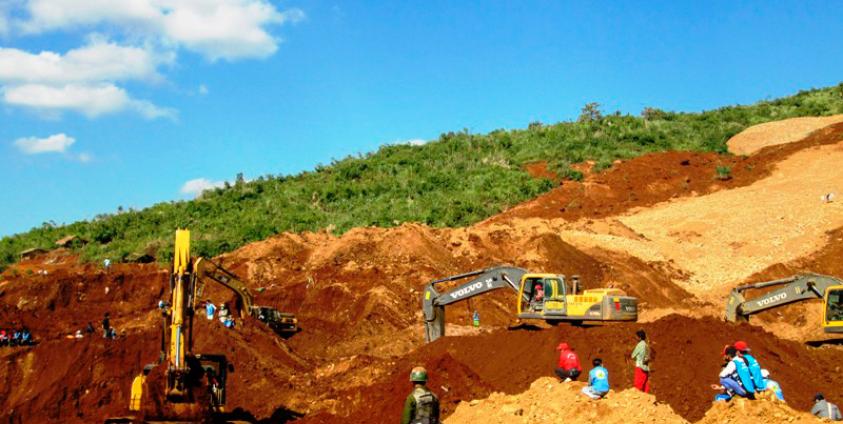 A soldier (C) stands guard as rescue workers search for the miners killed by a landslide at the Hpa Kant jade mining area, Kachin State, northern Myanmar, 23 November 2015. Photo: Zaw Moe Htet/EPA