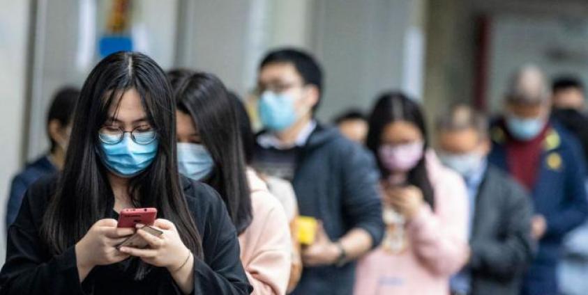 People queue outside a pharmacy as they won the lottery to buy protective masks, in Guangzhou, China, 13 February 2020. Photo: EPA