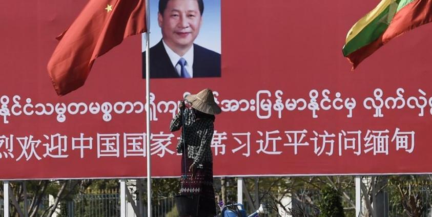 နေပြည်တော်တွင် စိုက်ထူထားသော တရုတ်သမ္မတရှီကျင့်ဖျင်အား ကြိုဆိုသည့် ဆိုင်းဘုတ်အနီးတွင် သန့်ရှင်းရေး ဆောင်ရွက်နေသော အမျိုးသမီးတစ်ဦးအား ၂၀၂၀ ဇန်နဝါရီလ ၁၇ ရက်နေ့က တွေ့မြင်ရစဉ်။ (ဓာတ်ပုံ - AFP)