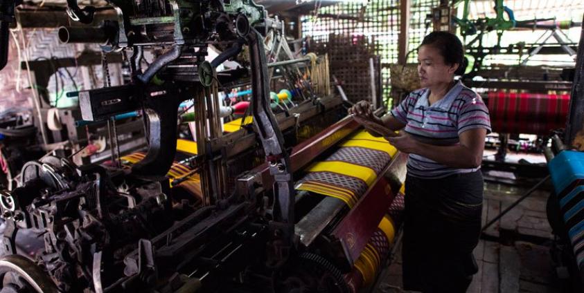 A woman working to make traditional Myanmar clothing at a workshop in Mandalay. Photo: Ye Aung Thu/AFP