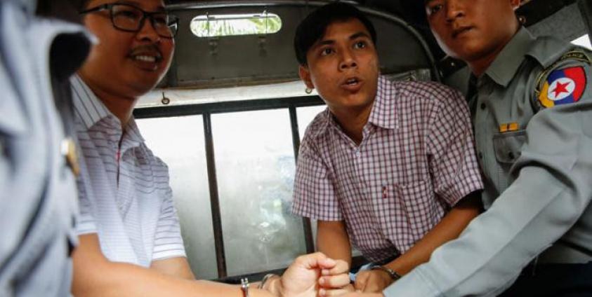 Reuters journalist Wa Lone (C-L), 31, and Kyaw Soe Oo (C-R), 28, sit in the police truck as they leave the court after the verdict has postponed at Insein township court, Yangon, Myanmar, 27 August 2018. Photo: Lynn Bo Bo/EPA