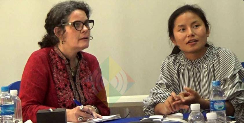 HRW မှ Heather Barr (ဘယ်) မှ မတ်လ ၂၅ ရက်နေ့ မြစ်ကြီးနားတွင် အစီရင်ခံစာ ရှင်းလင်းနေပုံ။