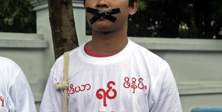 Reuters journalist Wa Lone wearing a t-shirt with a slogan reading, 'Stop killing press' and tapes on his mouth takes part in a protest over their jailed colleagues, near the Myanmar Peace Center in Yangon, 12 July 2014  (Photo: Nyein Chan Naing/EPA)