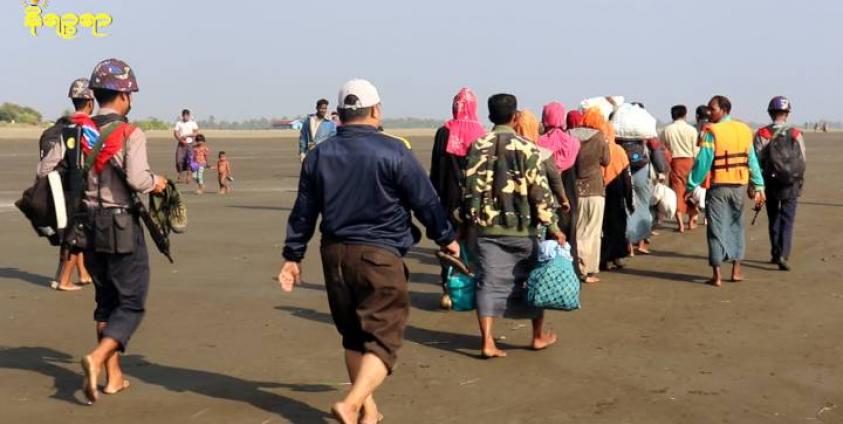 စစ်တွေကမ်းခြေတွင် မူဆလင်အချို့အား ရဲတပ်ဖွဲ့ဝင်အချို့က ခေါ်ဆောင်လာသည်ကို ၂ဝ၂ဝ ပြည့်နှစ်၊ ဇန်နဝါရီလအတွင်း တွေ့ရစဉ်။