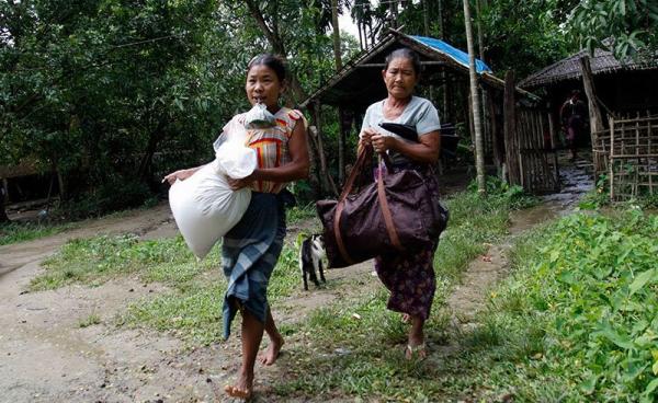 Villagers carry belongings as they prepare to flee from fighting at Aung Mingalar village near Maungdaw town of Bangladesh-Myanmar border, Rakhine State, western Myanmar, 13 October 2016. Photo: Nyunt Win/EPA