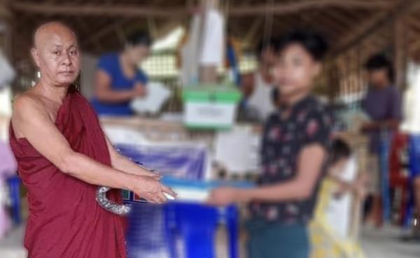 စစ်ဘေးရှောင်စခန်းမှ ကျောင်းသားများကို မြို့ဦးခေါင်းဆရာတော်က စာအုပ်စာတန်းများ ထောက်ပံ့နေသည်ကို ၂၀၂၂ ခုနှစ်၊ ဇွန်လက တွေ့ရစဉ်။ (ဓာတ်ပုံ - ALP)