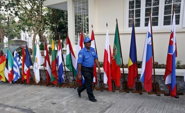 A security personnel walks past European countries flags during the opening ceremony of European Union office in Yangon, Myanmar, 28 April 2012. Photo: Nyein Chan Naing/EPA