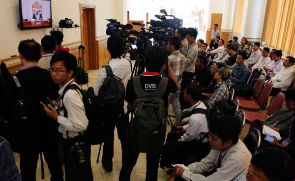 လွှတ်တော်အစည်းအဝေးခန်းမ အပြင်ဘက်ရှိ တီဗီတွင် သတင်းသမားများ သတင်းယူနေပုံ။ (ဓာတ်ပုံ- သက်ကို-မဇ္ဈိမ)