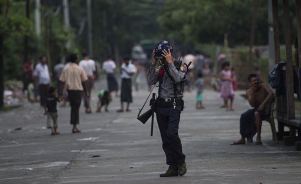 An armed Myanmar police officer stands guard in Aung Mingalar ward in Sittwe, the capital of Rakhine State. Photo: AFP