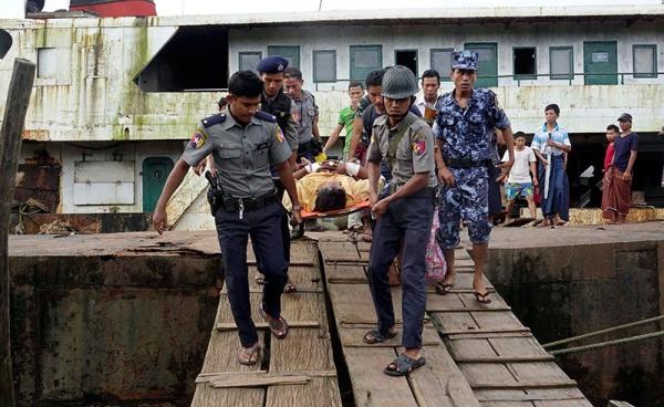 Myanmar policemen carry an injured border guard police (C) as he arrives to the Sittwe port, Sittwe, Rakhine State, western Myanmar, 26 August 2017. Photo: Nyunt WIn/EPA