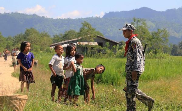 Myo ethnic children looks at a Myanmar border police in LaungDon, located in Rakhine State. Photo: AFP
