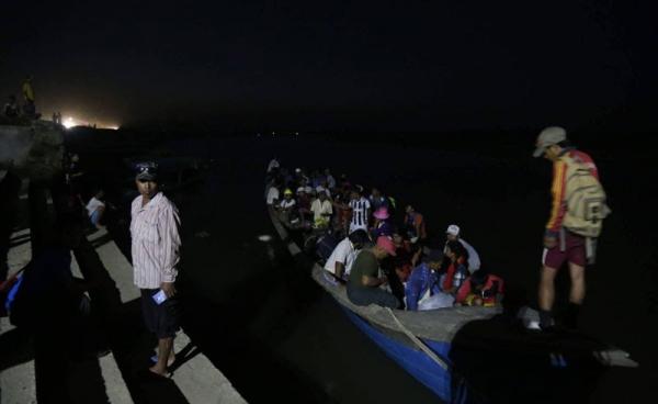 ဇွန် ၆ရက်ကမ့်ကွမ်းချောင်းဝ မှ စစ်ပြေးရှောင်များကို လှေများဖြင့် ခေါ်ဆောင်စဉ်။ Photo Credit - Hkun Awng Nlam facebook