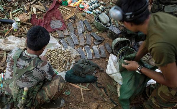 Rebels belonging to the Kachin Independence Army (KIA) ethnic group inspect government ammunitions and soldiers' helmets after two days of fighting with the Myanmar military near Laiza in Kachin State. Photo: AFP