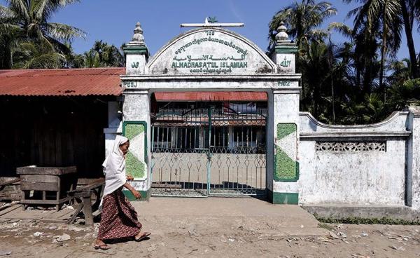 A Muslim woman walks by in front of the local mosque in the Aung Mingalar quarter in Sittwe, Myanmar. Photo: Nyein Chan Naing/EPA