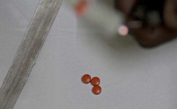 A man prepares methamphetamine pills before heating and inhaling them in a house on the outskirts of Yangon, Myanmar, 20 August 2014. Photo: Nyein Chan Naing/EPA